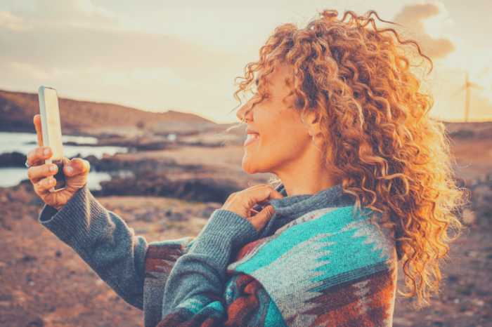 A woman on the beach Facetime's her coach.  You can do life coaching from anywhere.